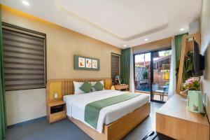 Un dormitorio con una cama grande y una ventana en The Linh Seaside Villa Hoi An en Hoi An