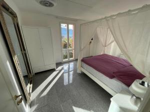 een slaapkamer met een hemelbed en een raam bij Villa Romantik am Lago Maggiore in Locarno