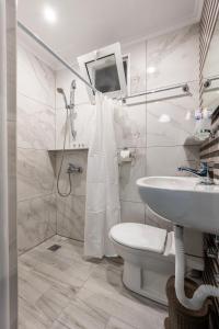 Baño blanco con aseo y lavamanos en Lefteris Apartment en Kardámaina