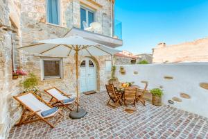 a patio with a table and chairs and an umbrella at Villa Nicola in Kissamos