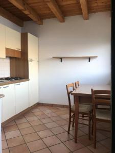 eine Küche mit einem Tisch und Stühlen im Zimmer in der Unterkunft Wohnung nr 7 im Casa Margherita mit Terrasse und Seeblick in Sommavilla