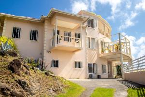 ein Haus auf einem Hügel mit Balkon in der Unterkunft La Cresta in Kingstown