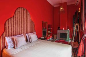 マラケシュにあるRiad OLIVE Privatif 4 Personnesの赤いベッドルーム(ベッド1台、暖炉付)