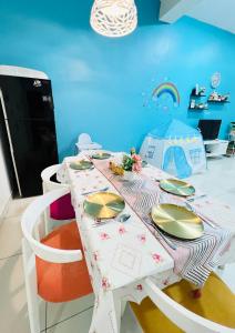 una mesa blanca con sillas y una mesa con platos. en THE BLUE HOUSE, en Kamunting