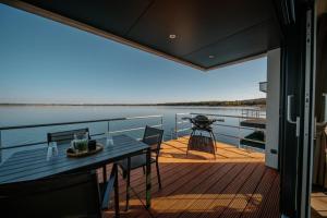 Hausboot Seeblick - LP7 في Laasow: شرفة مع طاولة وكراسي على قارب