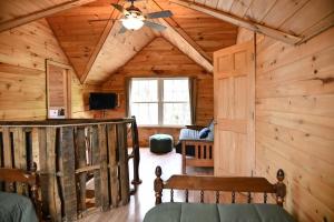 um quarto num chalé de madeira com uma ventoinha de tecto em Treehouse in Maine woods- The Grand Oak em North Lovell