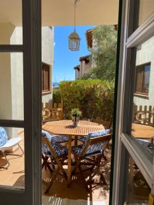 een patio met een tafel en stoelen en een raam bij The Blue Beach Apartment in Sa Ràpita