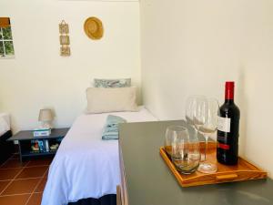 a room with a table with wine glasses and a bed at House of Skye in Cape Town