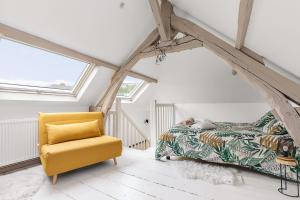 - une chambre avec un lit et une chaise jaune dans l'établissement Maison individuelle dans ancienne ecurie, à Rouen