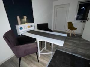 sala de estar con mesa blanca y sillas en Unsere Unterkünfte Ferienwohnung Superior für 1-4 Personen und Cozy Apartment für 1-2 Personen, en Goslar