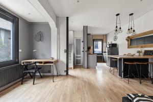 een keuken en een woonkamer met een tafel en stoelen bij Maison individuelle dans ancienne ecurie in Rouen