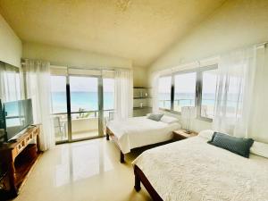 1 dormitorio con 2 camas y vistas al océano en Solymar corner penthouse condo en Cancún