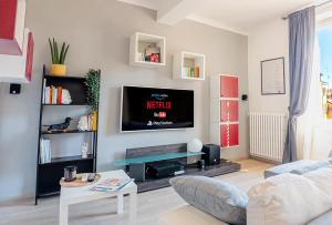 sala de estar con TV de pantalla plana en la pared en Luxury Apartment next to the Francescana, en Módena