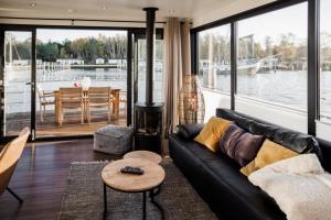 a living room with a couch and a view of the water at Hausboot freiZeit - LP4 in Peenemünde
