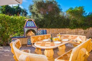 eine Terrasse mit einem Tisch, Stühlen und einem Kamin in der Unterkunft Villa Sanlio - PlusHolidays in La Canuta