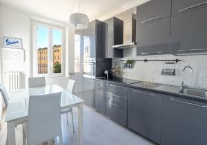 kuchnia z szarymi szafkami i białym blatem w obiekcie Luxury Apartment next to the Francescana w mieście Modena