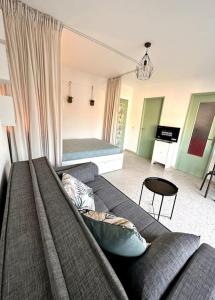 sala de estar con sofá y cama en Orangers - Bord de mer-Studio cosy refait à neuf 4 personnes en Cagnes-sur-Mer