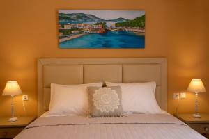 ein Schlafzimmer mit einem Bett und einem Gemälde an der Wand in der Unterkunft Dina Apartments Argostoli in Argostoli