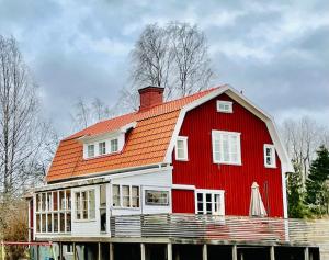 ein rotes Haus mit orangefarbenem Dach in der Unterkunft Mysigt hus för 2 familjer in Västervik