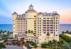 een groot hotel met de oceaan op de achtergrond bij Pelican Grand Beach Resort, a Noble House Resort in Fort Lauderdale