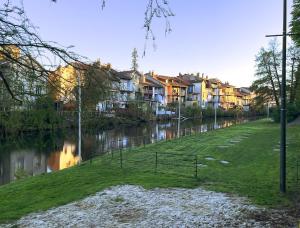 a row of houses on a river with houses at Les Jardins du Pont Rouge - Cosy et Calme in Aurillac
