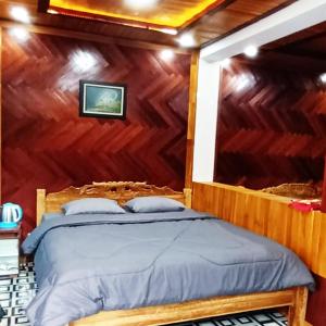 um quarto com uma cama numa parede de madeira em Villa Situ Jampang Campsite em Megamendung