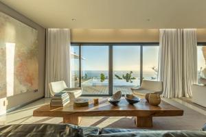 un soggiorno con tavolo e una grande finestra di The One Madeira a Ponta do Sol