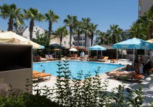 una piscina con sillas y sombrillas en Xeno Eftalia Resort Hotel, en Alanya