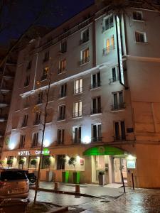 un edificio con un ombrello verde davanti di Campanile Paris 14 - Maine Montparnasse a Parigi