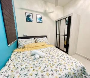 een slaapkamer met een bed met een geel en wit dekbed bij THE BLUE HOUSE in Kamunting
