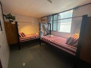 2 łóżka piętrowe w pokoju z oknem w obiekcie Por Chey w mieście Battambang