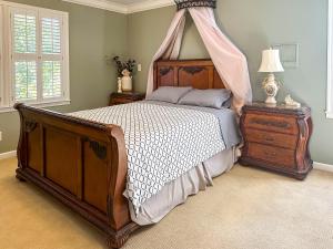 ein Schlafzimmer mit einem Himmelbett und einer Kommode in der Unterkunft Southern Home and fishing lake. in Gainesville