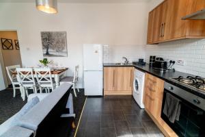 a kitchen with a table and a white refrigerator at Cozy Urban - Retreat Modern 1BR - Free Parking in Bristol