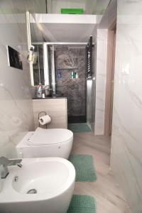 La salle de bains est pourvue de toilettes blanches et d'un lavabo. dans l'établissement Casa San Giacomo, à Barletta