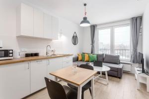 una cucina e un soggiorno con un divano e un tavolo di Enjoy! Ursynów a Varsavia