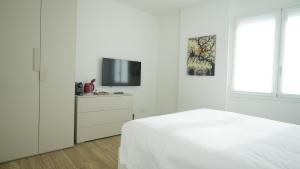 a white bedroom with a bed and a tv at Palazzo Gilberto in Padova