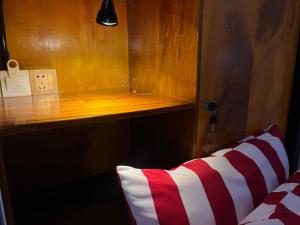 a bed with a red and white pillow in a room at Por Chey in Battambang