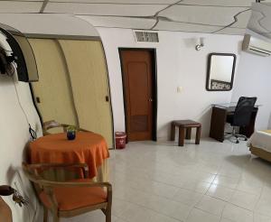 ネイバにあるHotel Sulicamのテーブル、ベッド、ドアが備わる部屋