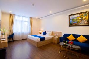 une chambre d'hôtel avec un lit et un canapé bleu dans l'établissement Sandals Star Hotel, à Ðưc Trọng