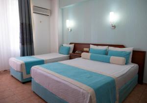 Habitación de hotel con 2 camas en azul y blanco en Xeno Eftalia Resort Hotel en Alanya