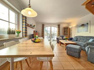 a living room with a table and a couch at Ferienhaus Baltrumkieker Links in Neßmersiel