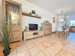 a living room with a television and a table at Ferienhaus Baltrumkieker Mitte in Neßmersiel