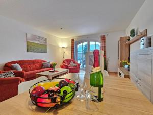 a bottle of wine and a bowl of fruit on a table at Ferienhaus Baltrumkieker Mitte in Neßmersiel