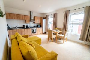 a living room with a yellow couch and a kitchen at Cozy Urban Retreat - Modern 1BR - Free Parking in Bristol