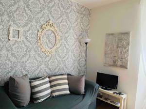 アルジェーニョにあるCharming & bright apartment Como lakefrontのリビングルーム(青いソファ、テレビ付)