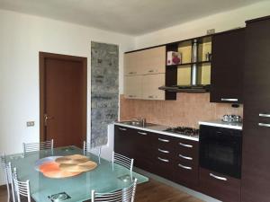eine Küche mit einem Glastisch mit Stühlen in der Unterkunft Charming & bright apartment Como lakefront in Argegno