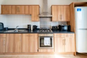 a kitchen with wooden cabinets and a stove top oven at Cozy Urban Retreat - Modern 1BR - Free Parking in Bristol