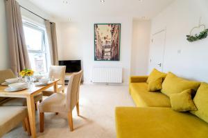 - un salon avec un canapé jaune et une table dans l'établissement Cozy Urban Retreat - Modern 1BR - Free Parking, à Bristol
