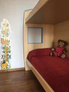 ein Teddybär auf einem Bett in einem Schlafzimmer in der Unterkunft Charming & bright apartment Como lakefront in Argegno