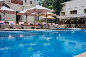 a swimming pool with chairs and umbrellas at Hotel Waterbuck in Nakuru